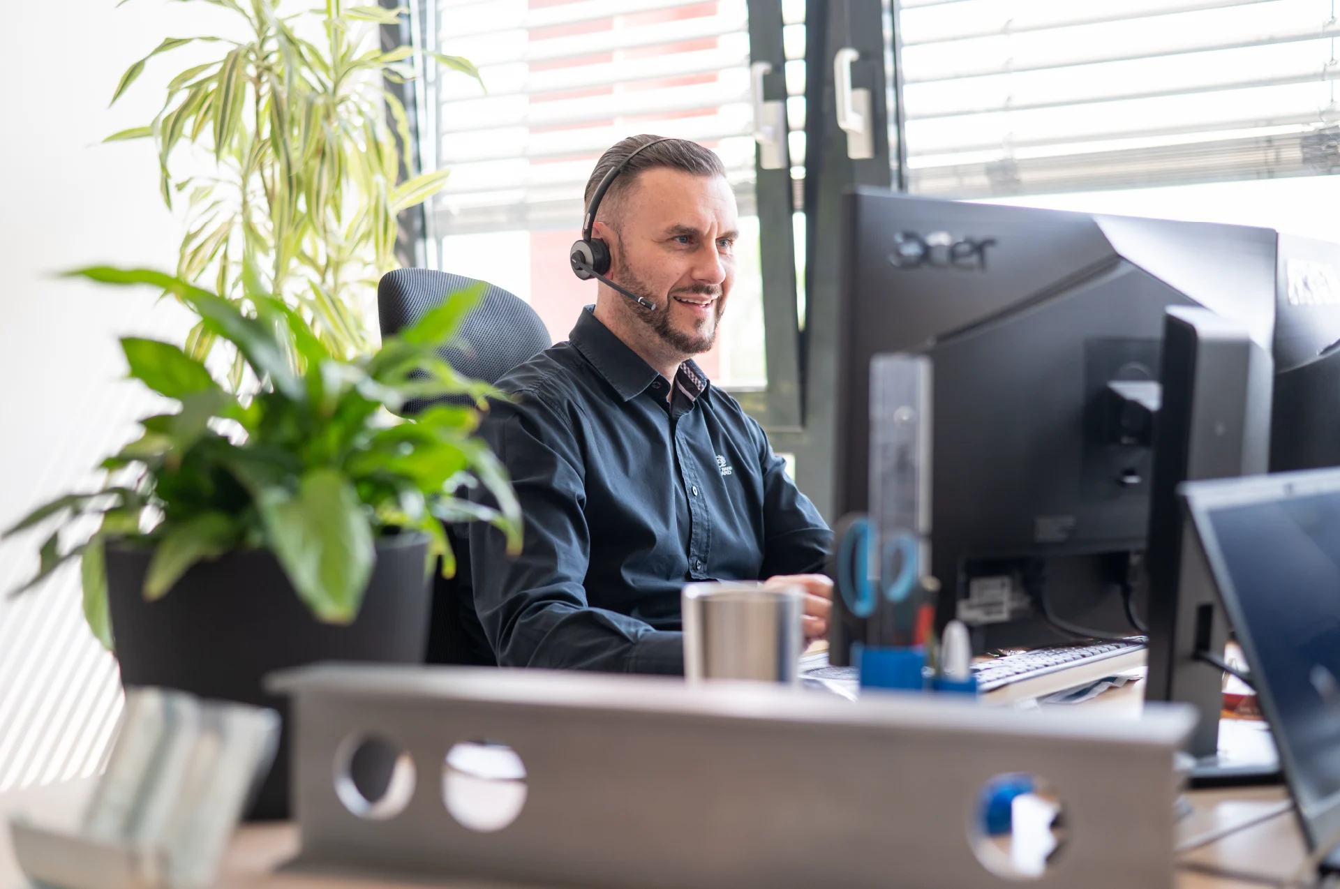 Photon Mitarbeiter mit Headset am Schreibtisch